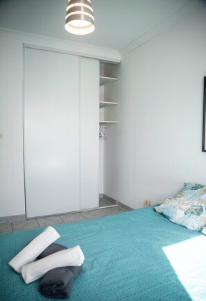 Ein Schlafzimmer mit einem Bett, einem Kleiderschrank und einem Hängebrett.
