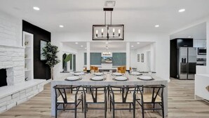 A modern kitchen with a central island, white cabinetry, and stainless steel appliances.