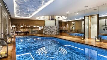 Una piscina techada, sillones reclinables de piscina