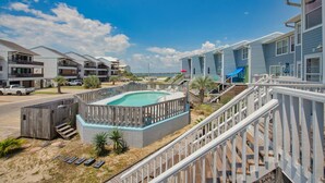 Ein Strandhotel mit Pool, mehreren Balkonen und einer blauen Rutsche.