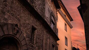 Um edifício histórico com fachada de pedra, porta de madeira e varanda.