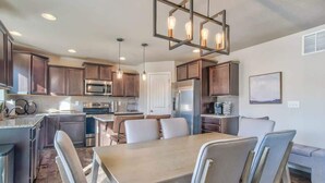 Une cuisine moderne avec des meubles en bois foncé, des appareils électroménagers en acier inoxydable et un îlot central.