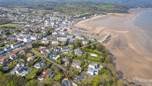 Vista aérea de un pueblo costero con playa, casas y una ubicación señalada, Sunningdale.