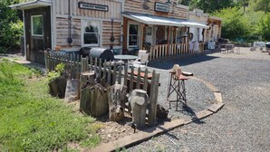 A rustic wooden building with a sign reading "RANCHO-MADERA" and "AMERICAN FARM MANAGEMENT". - Delightful Barn-Tavern Close to GIANT SEQUOIAS (Springville)