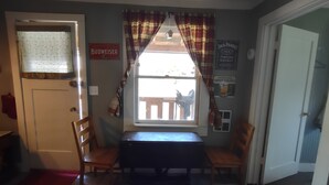 A room with a dining table and chairs, a window with plaid curtains, and a sign for Budweiser beer. - Delightful Barn-Tavern Close to GIANT SEQUOIAS (Springville)