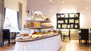 A buffet setup with various food items and a coffee machine. - Unitas Residence (Prague)