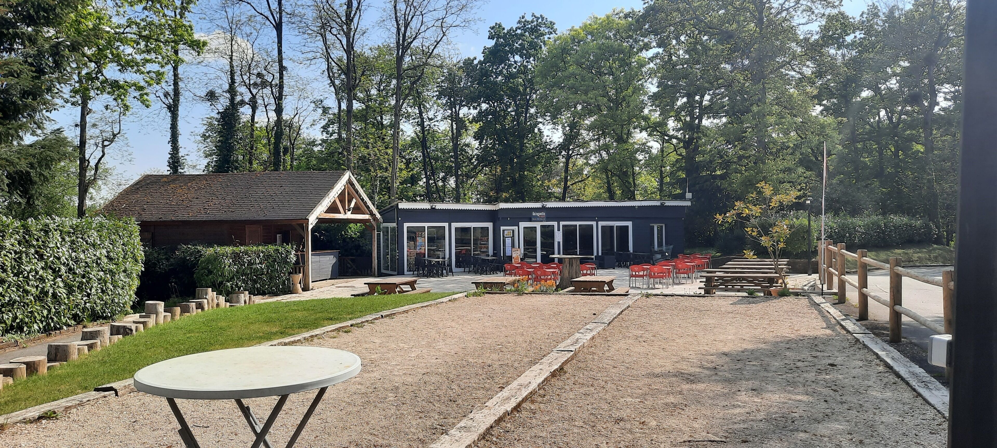 Een gebouw met een overdekte patio, buitenzitplaatsen en een grindpad.