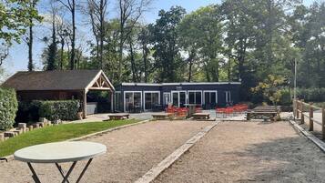Een gebouw met een overdekte patio, buitenzitplaatsen en een grindpad.