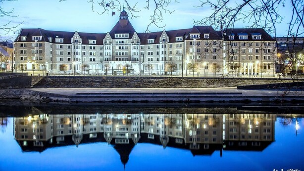 Un grand hôtel à plusieurs étages, doté d’une tour centrale et de plusieurs ailes.