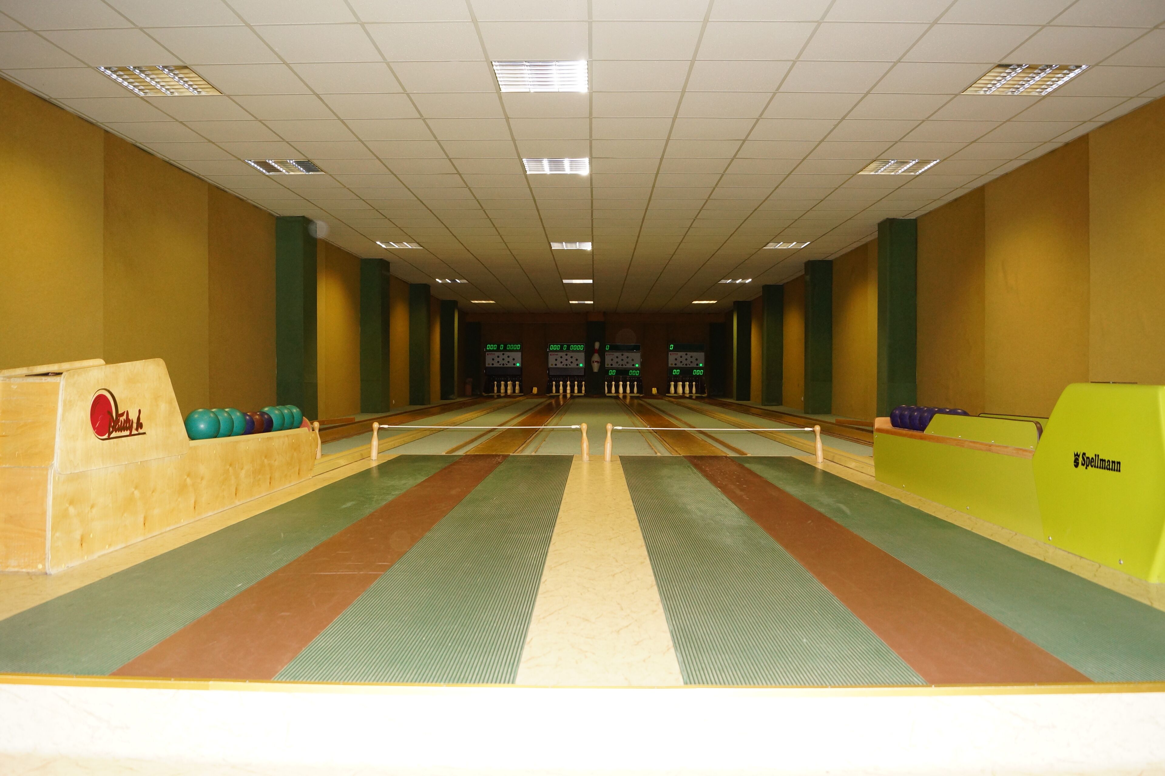 A bowling alley with lanes, pins, and a scoreboard.