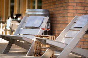Two lounge chairs with a small wooden table between them, each with a wine glass on the table. - Waldhotel Boizenburg (Boizenburg)