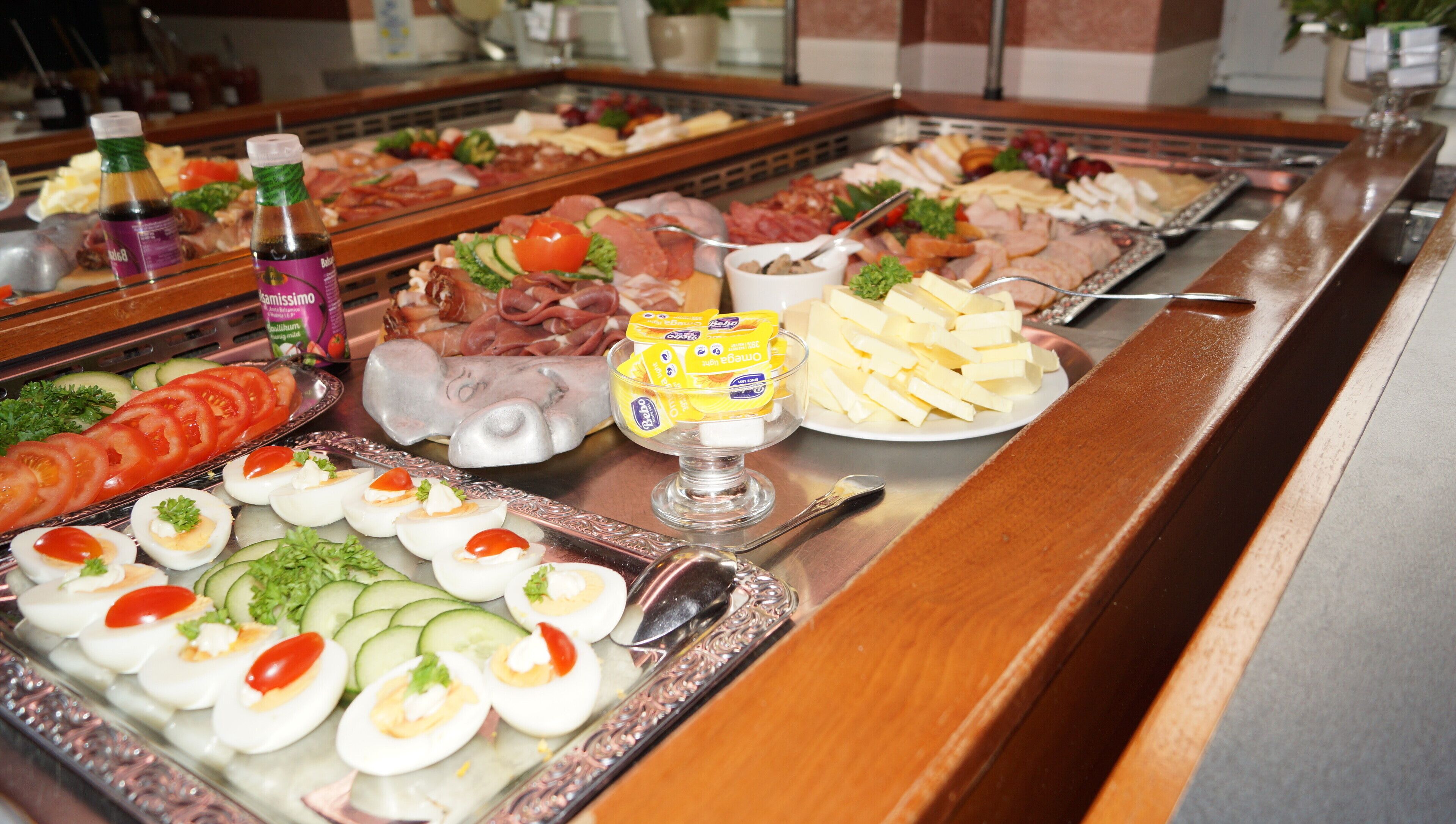 Un buffet proposant une variété de plats, notamment des viandes, des fromages et des salades.