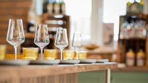 Een bar met krukken en glazen op een houten toonbank.