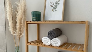 Een houten plank met handdoeken en een lijst met een botanische afbeelding.