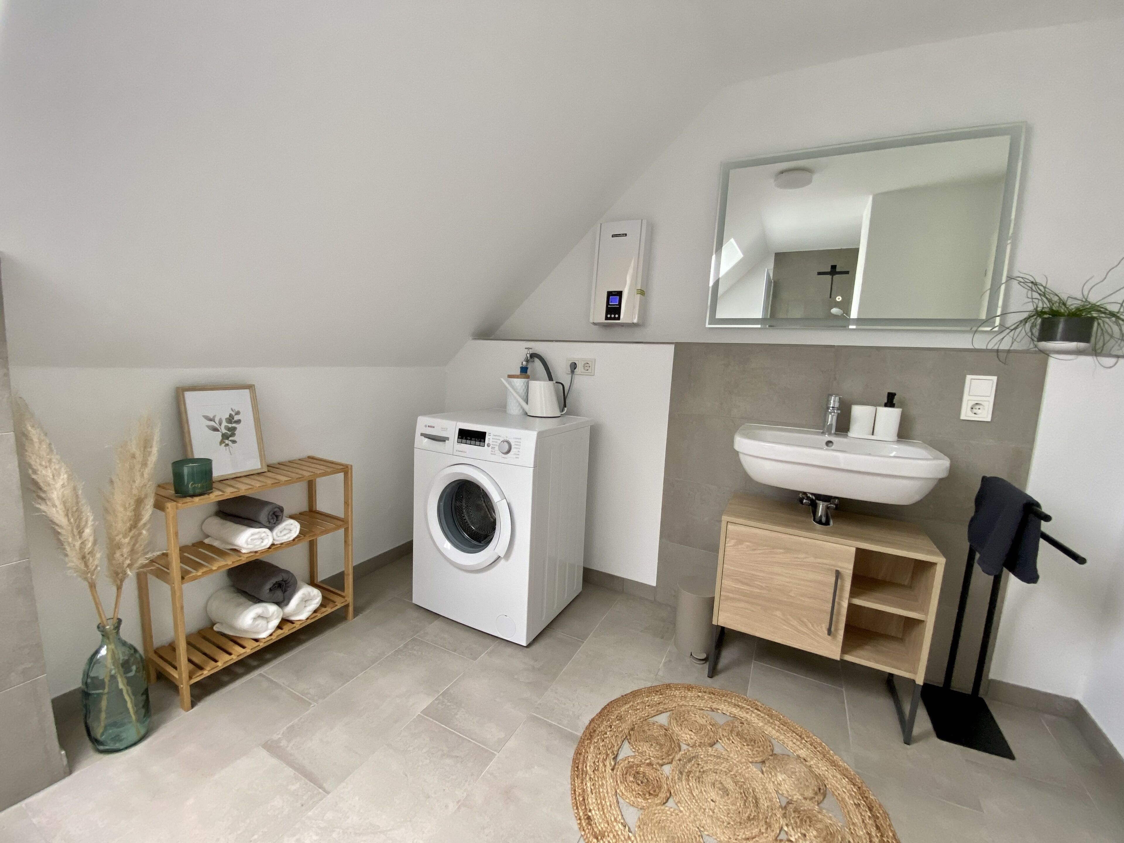 Un baño moderno con lavadora, lavamanos y espejo.