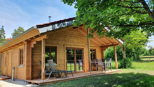 A wooden cabin with a covered porch, large windows, and outdoor seating. - Ecological new-build wooden block vacation home - free AlbCard from 2025  (Hayingen)
