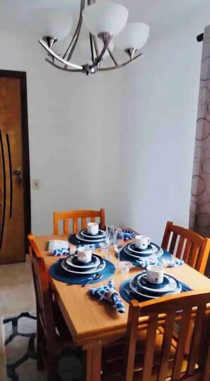 A dining area with a wooden table set for six, surrounded by wooden chairs. - CONFORTO & LOCALIZAÇÃO GREAT PLACE TO STAY (São Paulo)