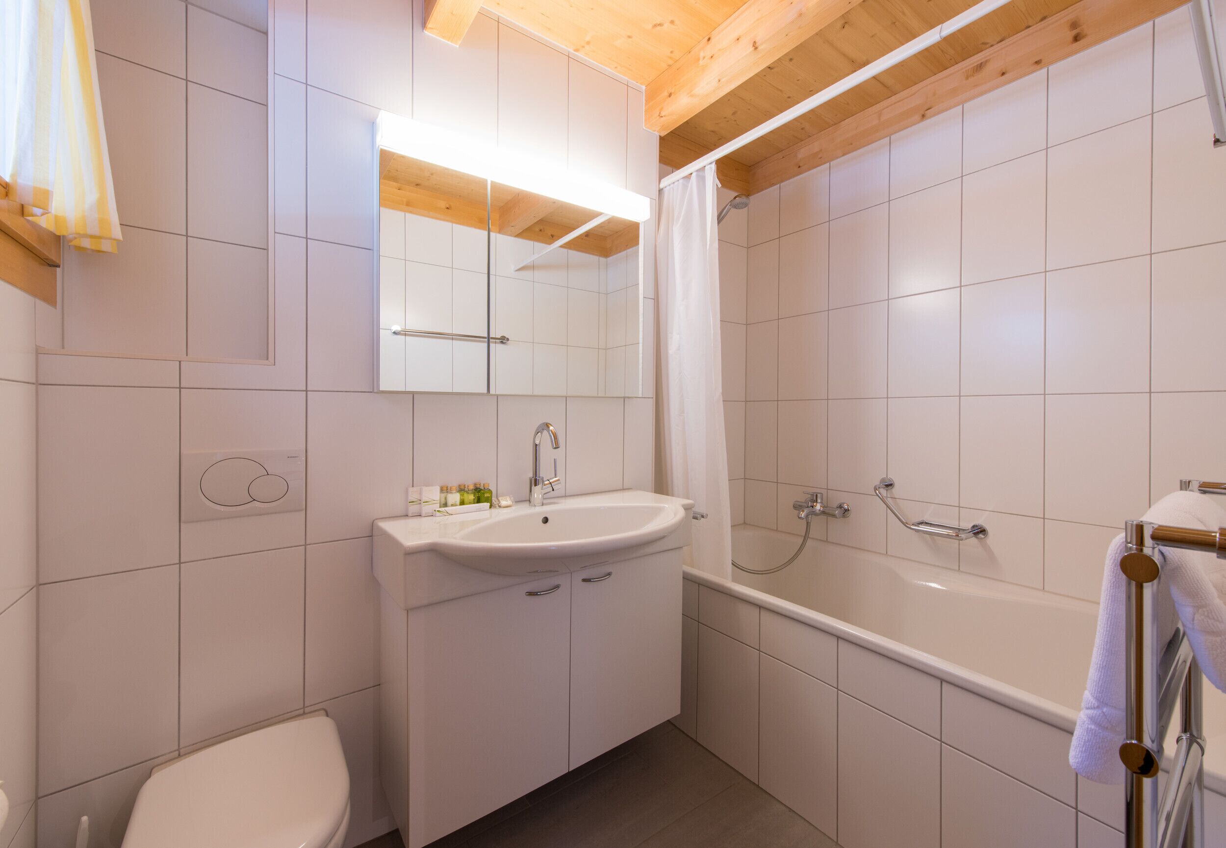 A modern bathroom with a white sink, toilet, and bathtub.