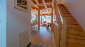 A wooden staircase leading to a room with a view of the outdoors.