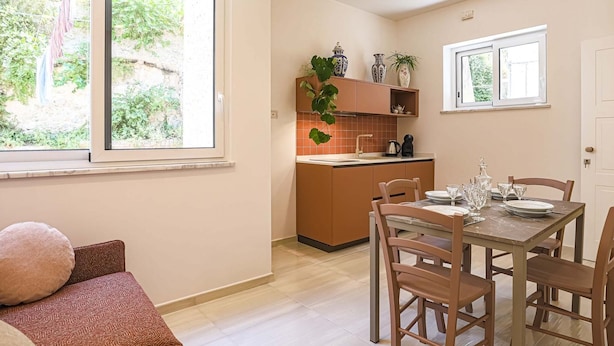 Un appartamento moderno con zona pranzo, cucina e ampie finestre.