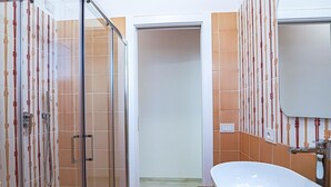 Un bagno con doccia, lavandino e specchio.