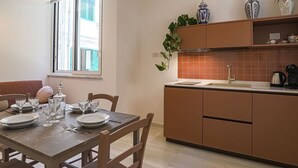 Una cucina moderna con zona pranzo, una finestra, una pianta e una macchina per il caffè.
