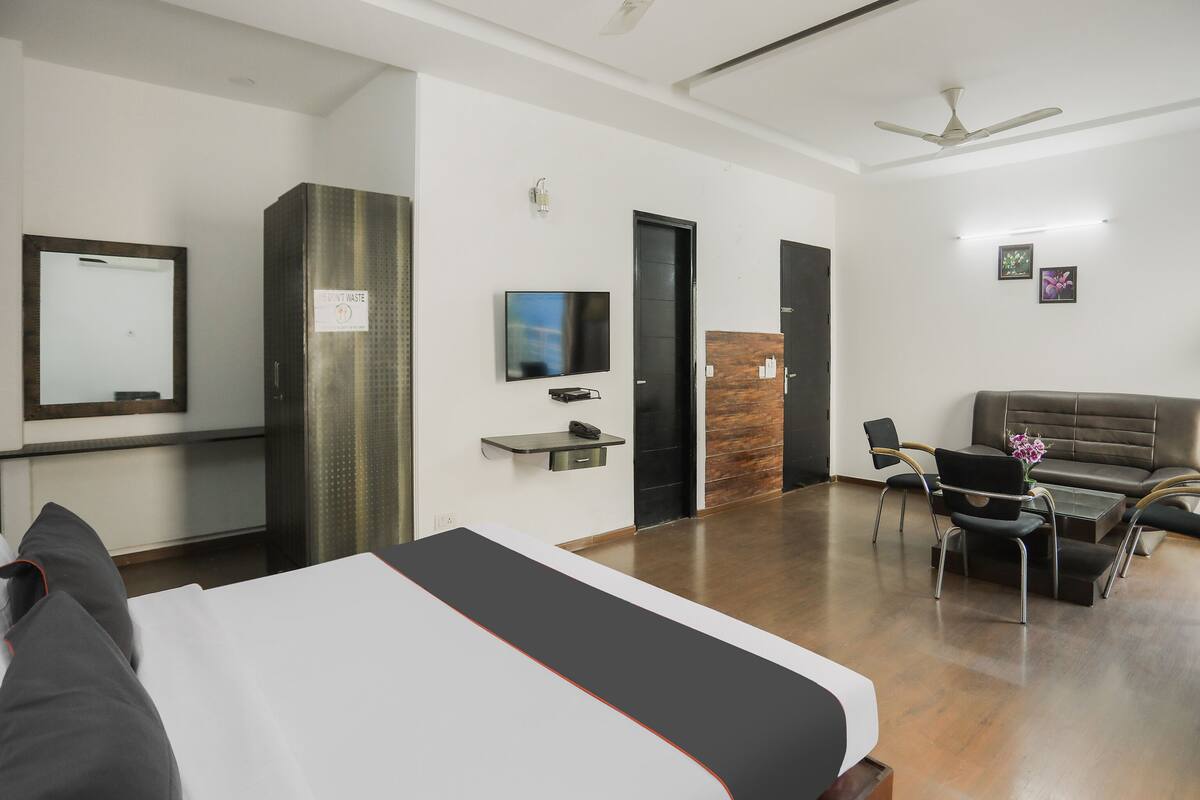 A hotel room with a bed, a desk, a TV, a wardrobe, and a sofa.