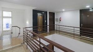 A hotel room with a balcony, a fire extinguisher, and a door with a number. - Dormy Villa By Dreamz Hospitality (Gurugram)