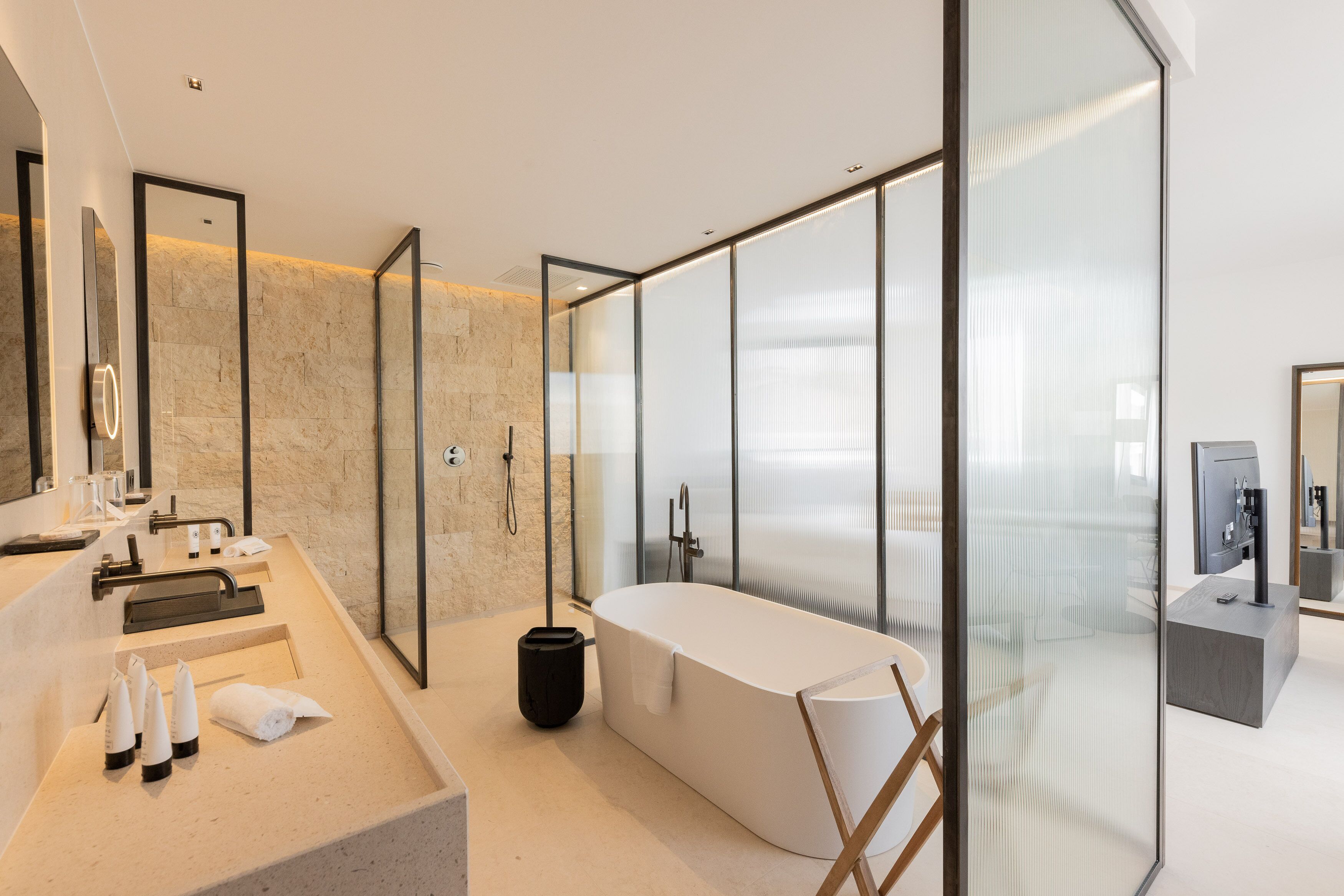 A modern bathroom with a large bathtub, a glass shower enclosure, and a vanity with a mirror and sink.