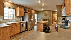 A modern kitchen with wooden cabinets, stainless steel appliances, and a central island.