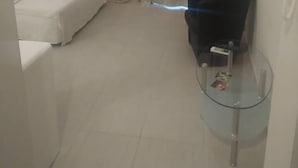 A small, sparsely furnished room with a white sofa, a glass table, and a black chair. - On the Metro Station of Korydallos, Near Peiraeus (Korydallos)