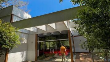 A modern building with a glass entrance, a wooden deck, and a garden area.
