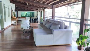 Un espacio de estar al aire libre cubierto con un sofá, sillas y una mesita.