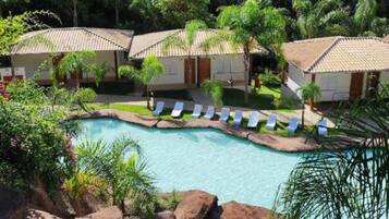 Resort com piscina, cadeiras de descanso e cachoeira.