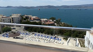 A balcony with blue lounge chairs and a view of the sea. - Roseira Beach Resort (Milas)
