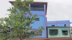 A multi-story building with a blue and purple facade, featuring balconies and air conditioning units. - Solanos Transient House (Pasay)