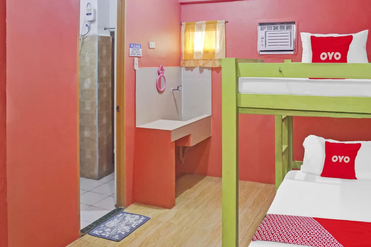 A room with a bunk bed, a sink, and a shower.