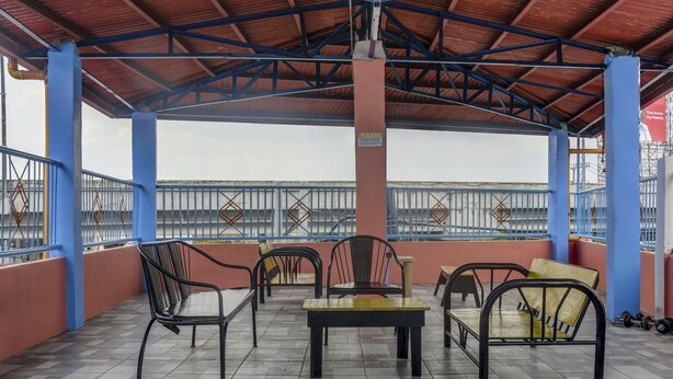 A covered outdoor seating area with tiled flooring, metal chairs, and tables. - Solanos Transient House (Pasay)