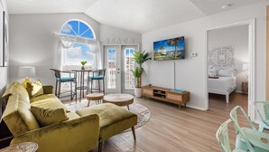A modern living room with a sofa, chairs, a dining table, and a bed. - Ocean View Condo (Corpus Christi)