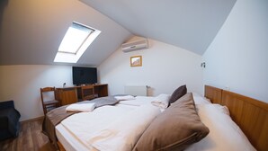 A bedroom with a bed, a desk, a chair, a television, and a skylight. - Romantic attic 1/2 room (Izola)