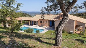 A house with a swimming pool, a covered patio, and a view of the countryside. - Magnificent pool villa between sea and mountains (Céret)