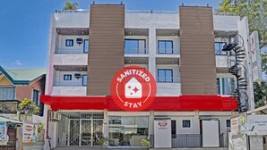 A multi-story building with a prominent red and white sign indicating it is a sanitized hotel. - OYO 869 Jnv Dream Hotel (Subic)