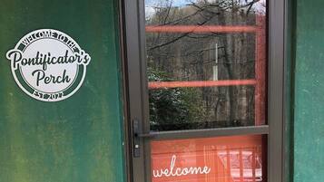 A door with a 'welcome' sign and a 'Pontificator's Perch' sign on the wall.