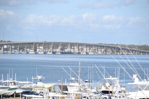 Boats docked at the marina, with a bridge spanning the water in the background.