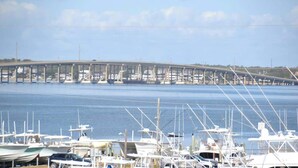 A marina with boats docked, a bridge in the background, and a clear sky. - Unique 3BR Home with great views Beach Access (Atlantic Beach)