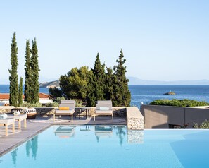 A poolside area with lounge chairs and a view of the sea. - Pelagoon Skiathos (Skiathos)