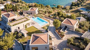 Zona residencial costera con casas modernas, una piscina y vistas al mar.