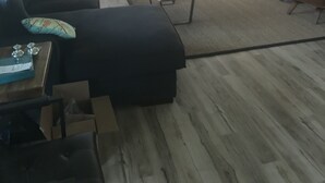 Un salon moderne comprenant un canapé, des fauteuils, une table basse et un ventilateur de plafond.