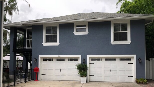 A two-story house with a garage, a covered patio, and a small balcony. - Amazing Five-Star Luxury Thornton Park two Bedroom Apt - close to Kia Center. (Orlando)