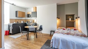 A compact hotel room with a kitchenette, a dining area, and a bed. - Studio A, in the center of town, cosy and warm... (La Roche-sur-Yon)